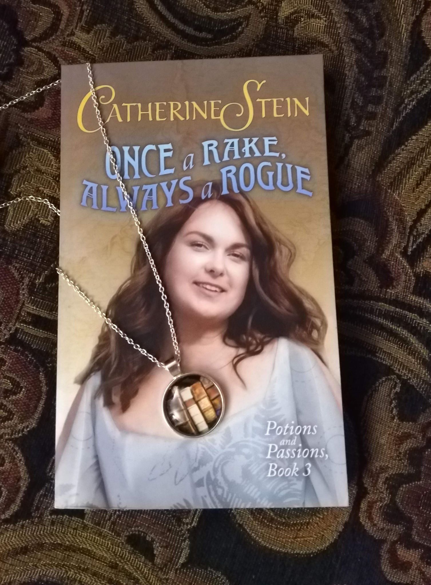 paperback copy and necklace with book pendant