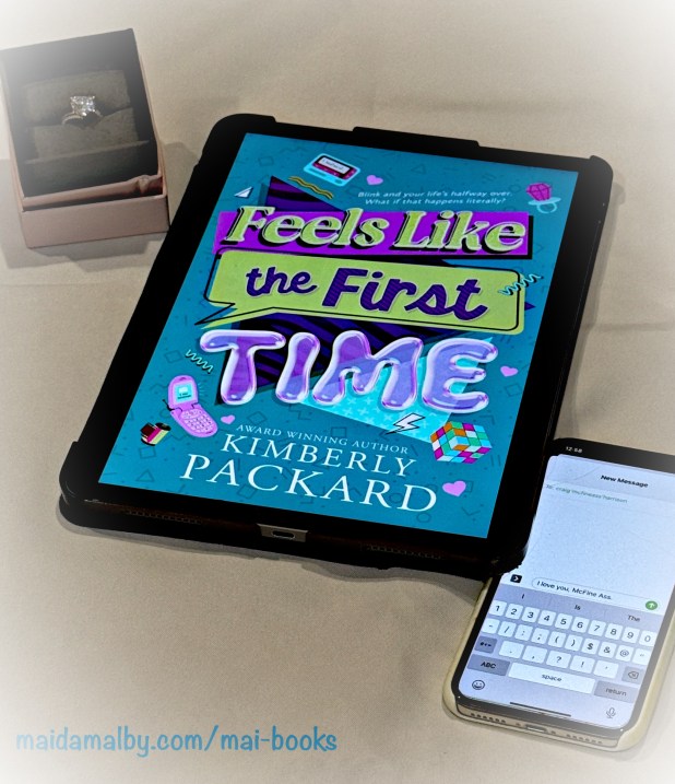 an iPad showing the cover of the book with an engagement ring in a box and a phone showing a text message